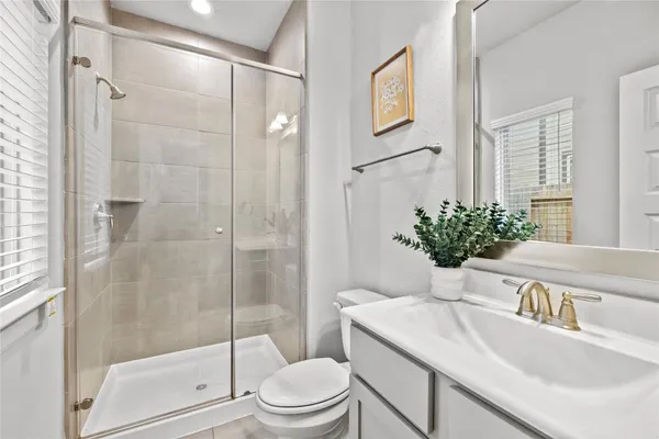 a bathroom with a granite countertop sink a toilet and shower