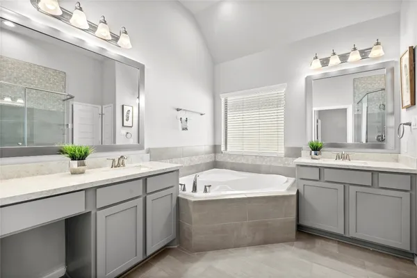 a bathroom with a tub a sink and mirror