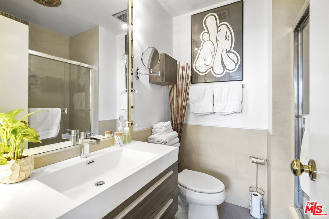 100 South Doheny Drive, Unit 506 Los Angeles, CA 90048 - Photo 9 of 17 a bathroom with a sink a toilet and a mirror