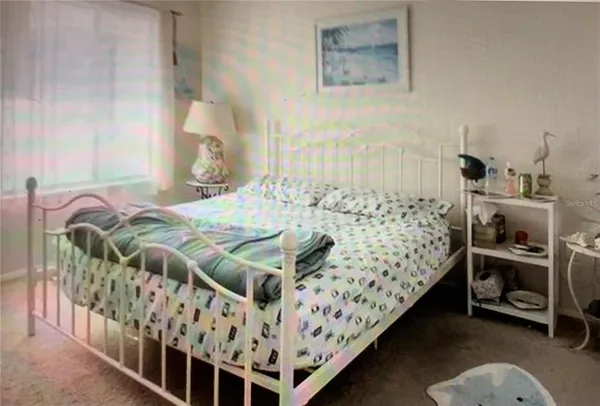 a bed sitting in a bedroom next to a window