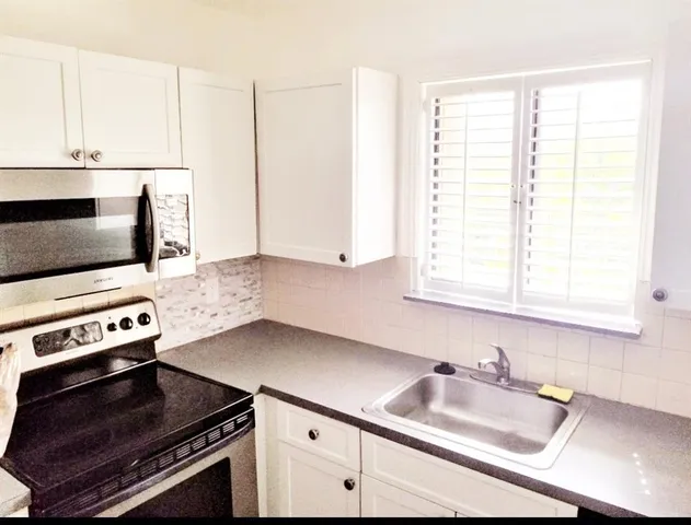 a kitchen with stainless steel appliances a sink stove and microwave