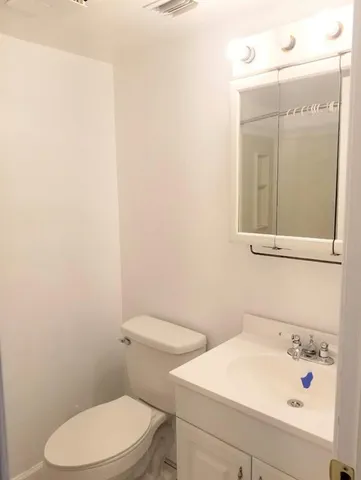 a bathroom with a sink a toilet and mirror