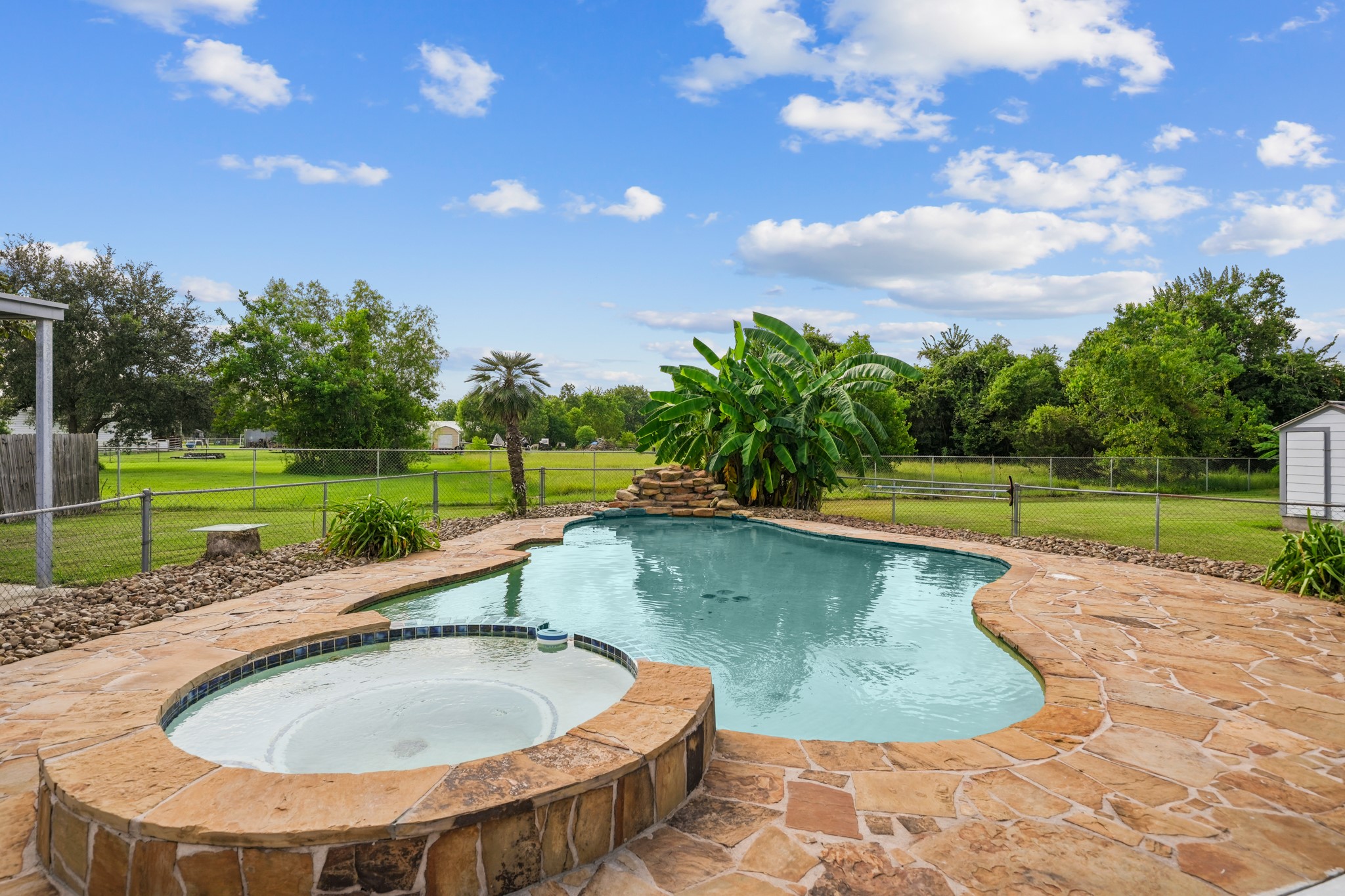 4435 South Tower Road Santa Fe, TX 77517 - Photo 24 of 35 The backyard centerpiece is a custom Anthony Sylvan pool featuring a built-in spa, waterfall, and flagstone decking for your own private retreat.