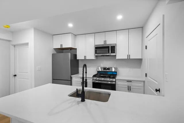 a kitchen with stainless steel appliances a refrigerator sink and stove top oven