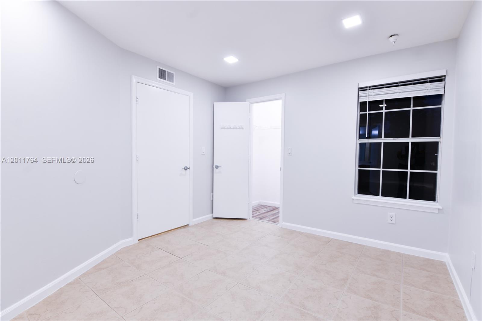 1011 Crystal Way, Unit D Delray Beach, FL 33444 - Photo 4 of 9 an empty room with a empty space and windows