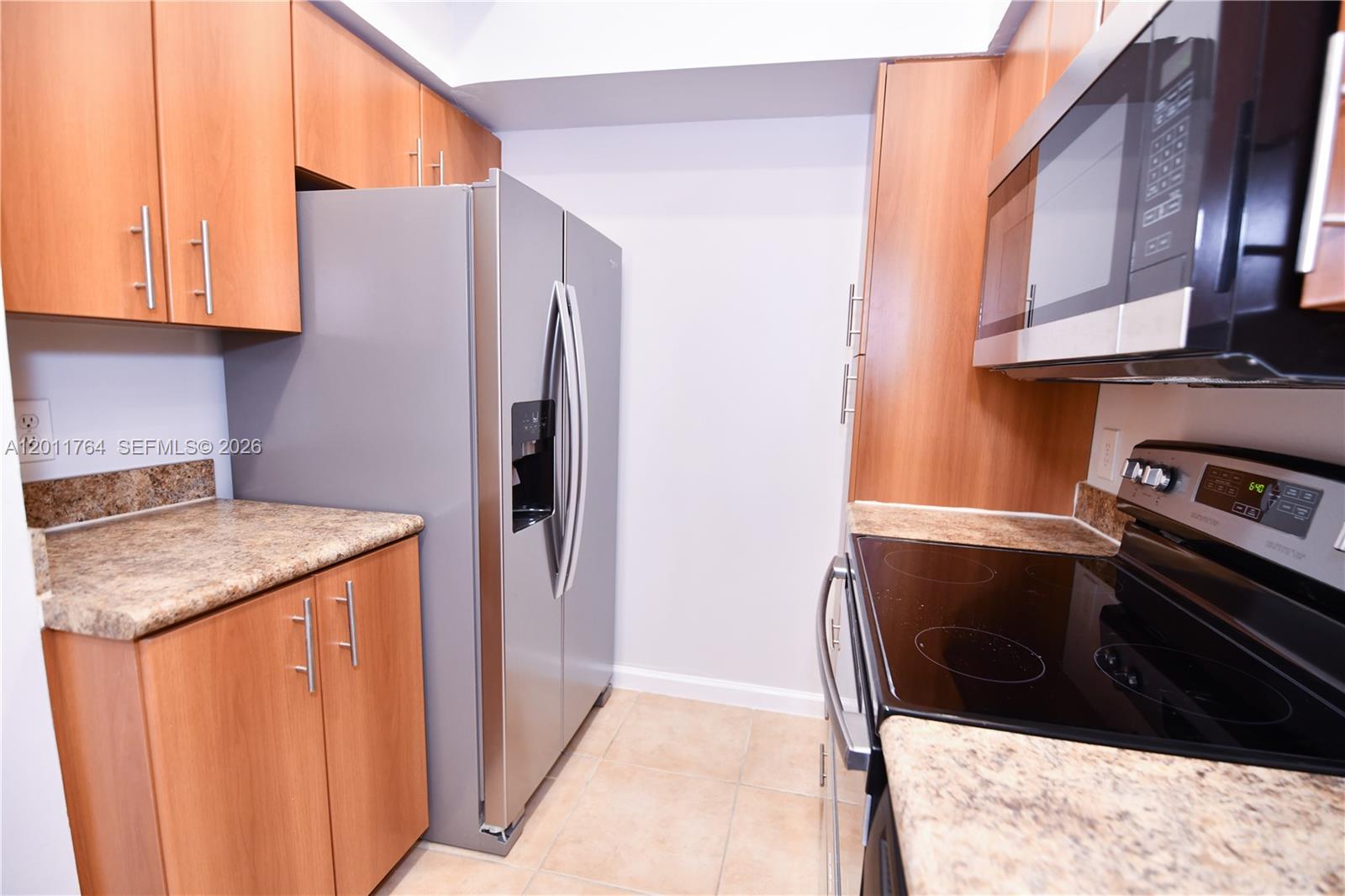 1011 Crystal Way, Unit D Delray Beach, FL 33444 - Photo 8 of 9 a kitchen with stainless steel appliances granite countertop a refrigerator and a stove