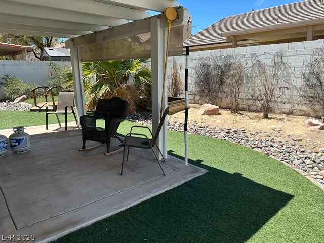 686 Skyline Road Henderson, NV 89002 - Photo 11 of 13 A covered concrete patio overlooks a low-maintenance backyard enclosed by a solid privacy wall.