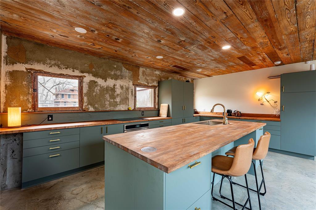 621 South Main Street Paris, TX 75460 - Photo 21 of 30 Kitchen with concrete floors, a sink, butcher block countertops, green cabinets, and wooden ceiling