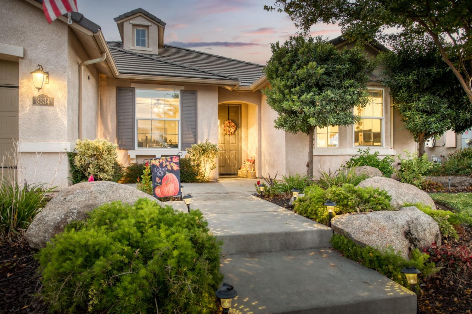 3334 Bellaire Avenue Clovis, CA 93619 - Photo 3 of 54 a front view of a house with large trees and plants
