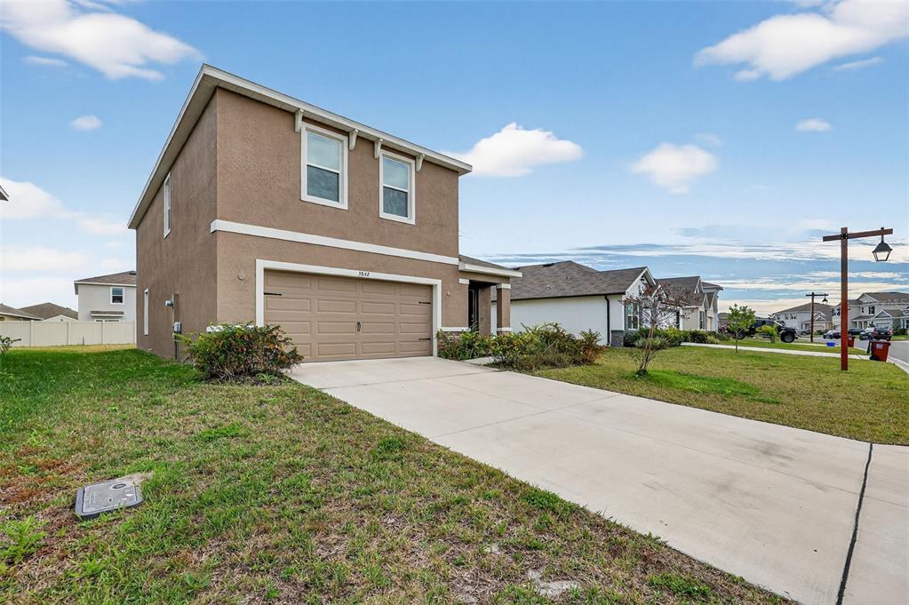 3842 Sunny Spring Street Plant City, FL 33565 - Photo 24 of 46 a front view of a house with a yard and garage
