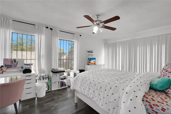 a living room with furniture a flat screen tv and floor to ceiling window