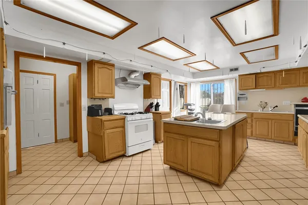 a kitchen with stainless steel appliances granite countertop a stove top oven a sink dishwasher and white cabinets