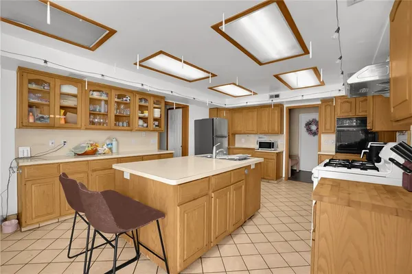 a kitchen with stainless steel appliances kitchen island granite countertop a sink and cabinets
