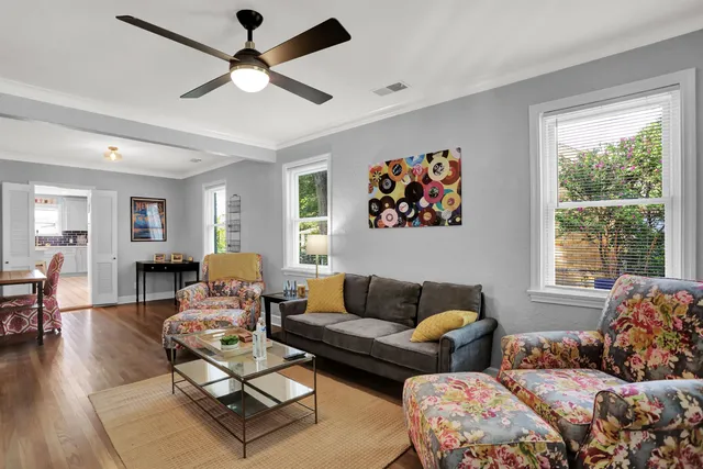 a living room with furniture ceiling fan and a window