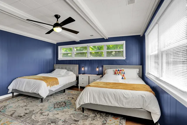 a bedroom with 2 bed and a window