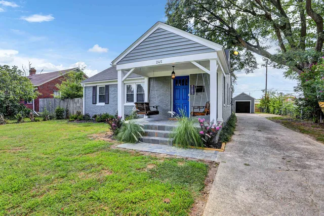 a view of a house with a yard and potted plants