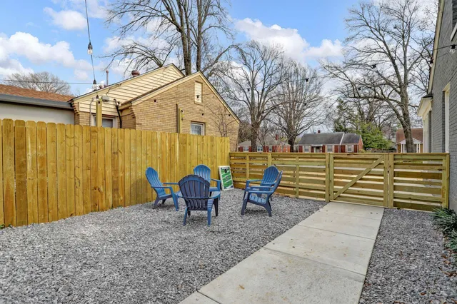 a backyard of a house with table and chairs