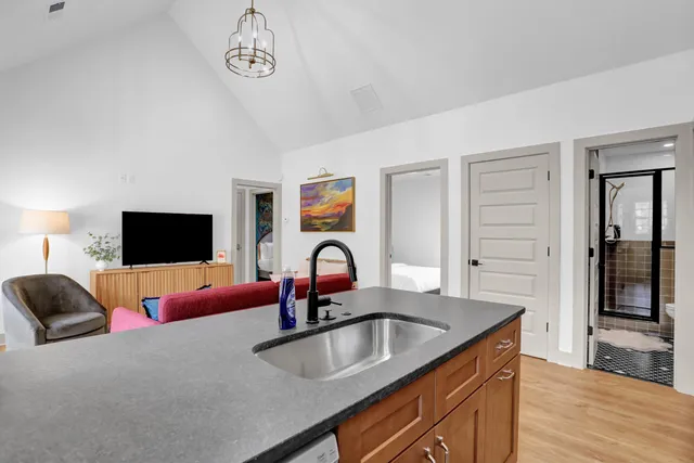 a kitchen with a granite countertop sink a stove and a refrigerator with wooden floor