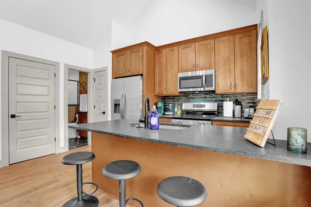 a kitchen with stainless steel appliances granite countertop a stove a sink and a refrigerator