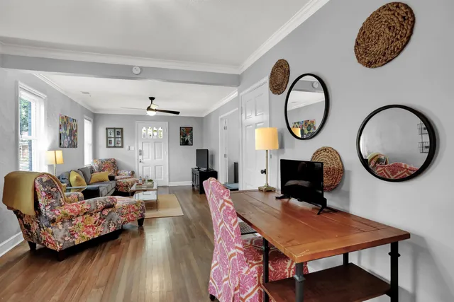 a living room with furniture a clock on wall and a mirror