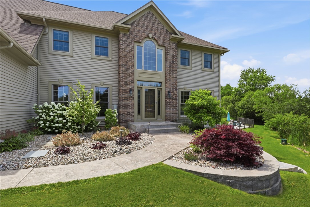 2057 Stirnie Road Victor, NY 14564 - Photo 5 of 48 The two-story front entrance features an elegant covered portico supported by classic columns. A large decorative arched window pairs beautifully with the front door and side-lites, creating a truly sophisticated focal point.