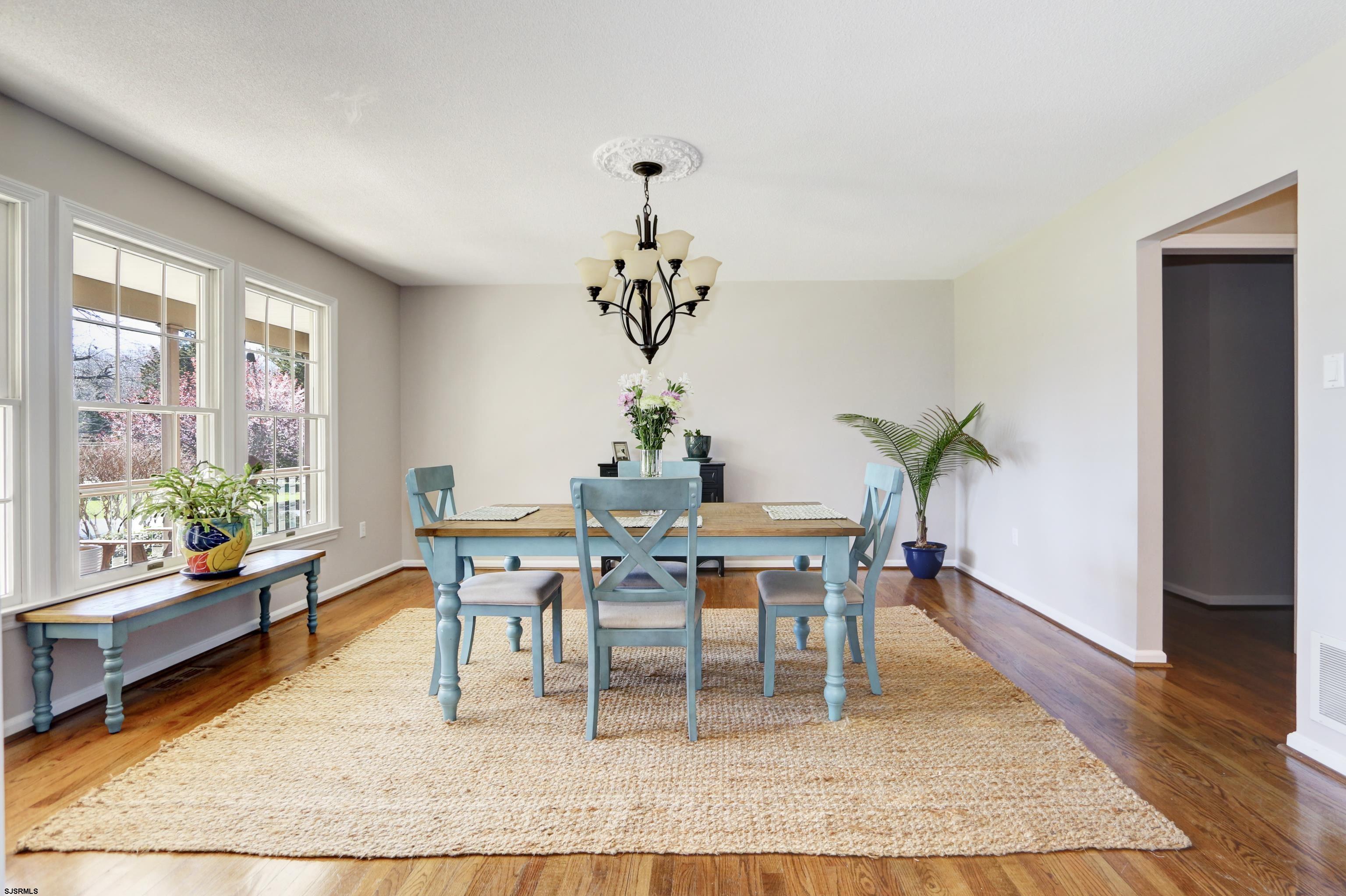 1322 Shore Road Palermo, NJ 08230 - Photo 5 of 56 a dining room with wooden floor a chandelier a glass table and a window