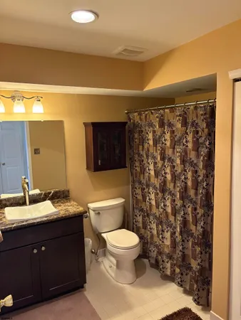 a bathroom with a granite countertop toilet sink and mirror