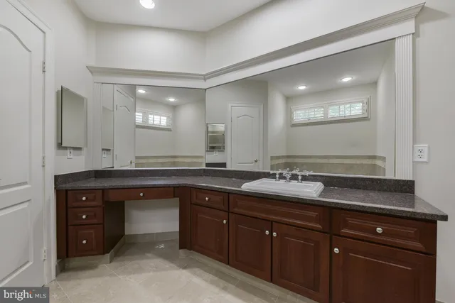 a spacious bathroom with a granite countertop sink and a mirror