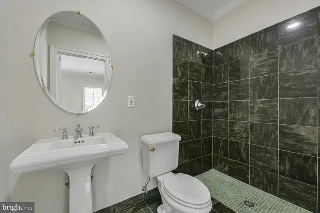 a bathroom with a sink toilet and a mirror