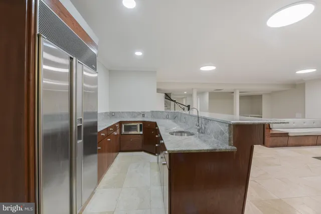 a kitchen with kitchen island a counter top space cabinets and stainless steel appliances