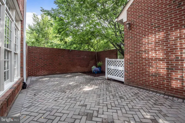 a front view of a residential apartment building with a yard and potted plants