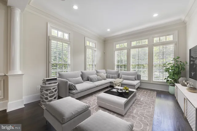 a living room with furniture and floor to ceiling windows