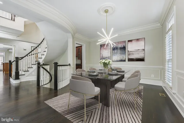 a dining room with wooden floor a chandelier a wooden table and chairs