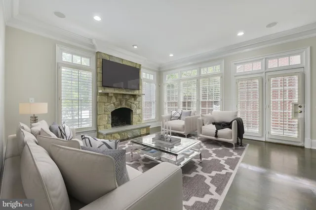 a living room with furniture a fireplace and a floor to ceiling window