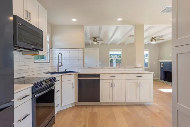 a large kitchen with stainless steel appliances granite countertop a stove and a sink