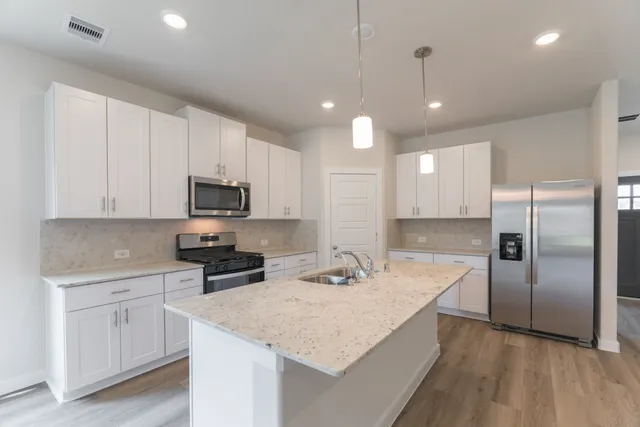a kitchen with white cabinets and stainless steel appliances
