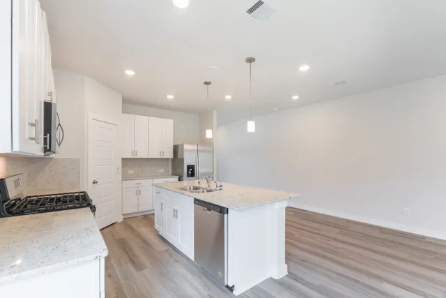 a kitchen with a sink stove top oven and cabinets