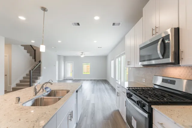 a kitchen with a sink stove and cabinets