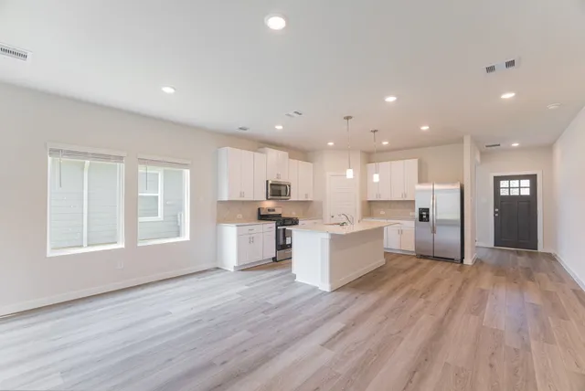 a kitchen with granite countertop a sink stove and cabinets