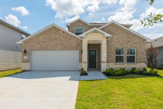 a front view of a house with a yard and garage