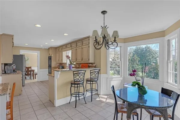 a view of a dining room and livingroom furniture a rug a potted plant and a chandelier