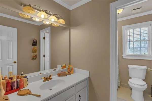 a bathroom with a sink vanity granite and toilet