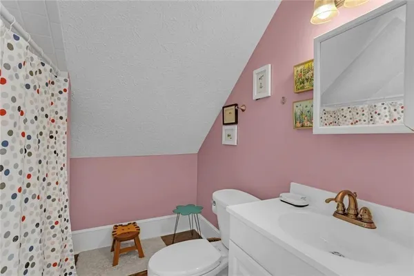 a bathroom with a sink a toilet and a shower curtain