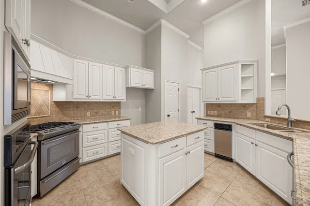 a kitchen with granite countertop a stove sink and cabinets