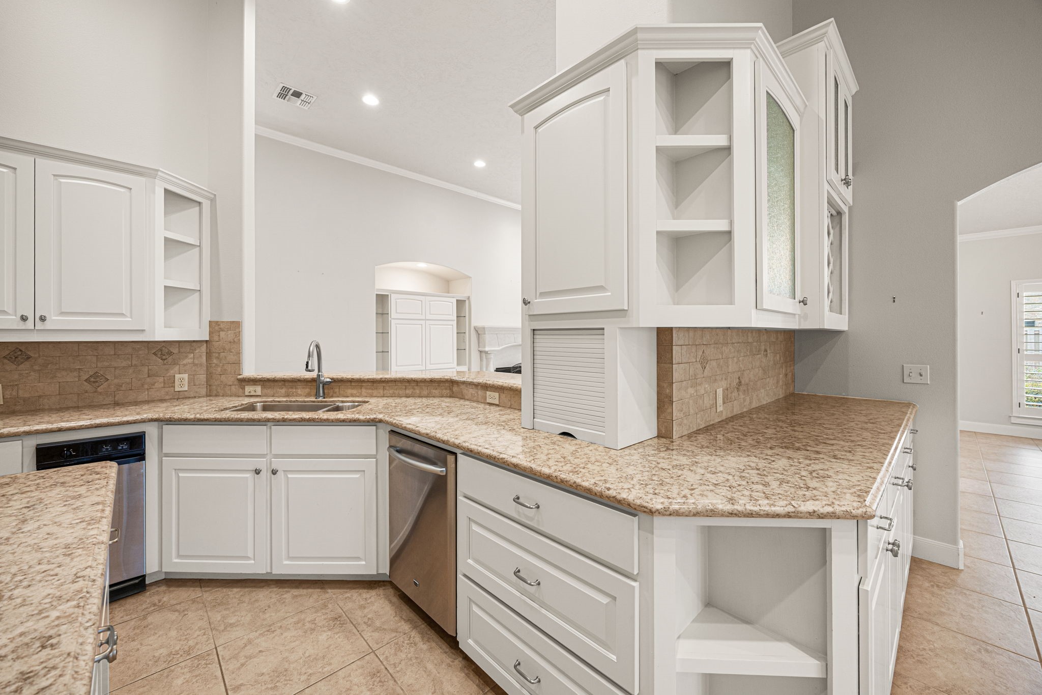 1220 Travis Street Columbus, TX 78934 - Photo 18 of 39 a kitchen with a sink dishwasher a stove and white cabinets