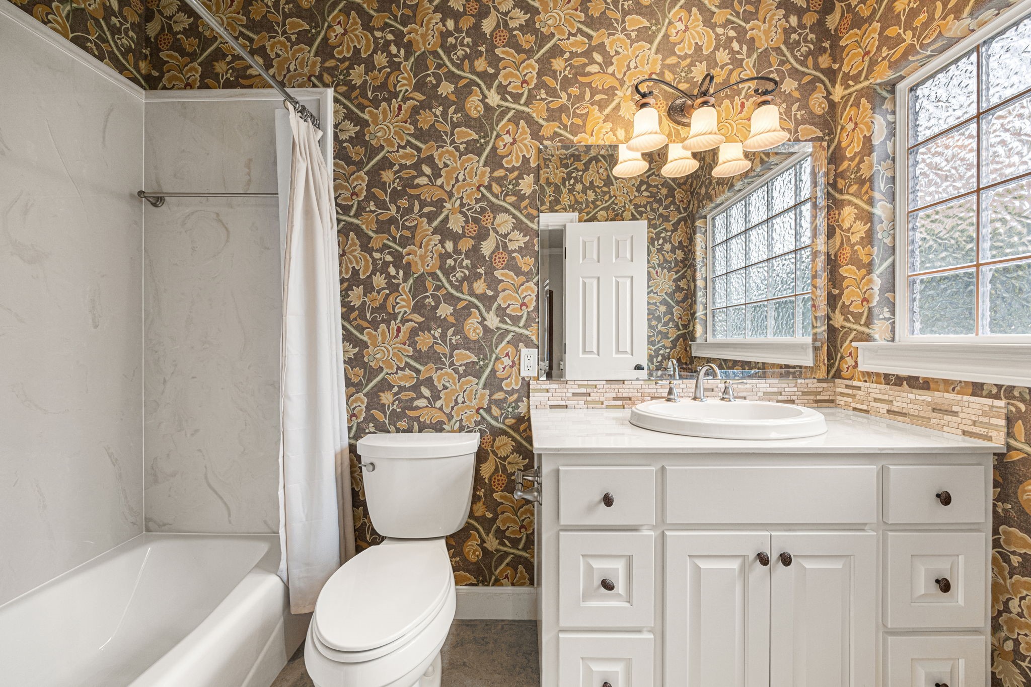 1220 Travis Street Columbus, TX 78934 - Photo 28 of 39 a bathroom with a granite countertop toilet sink and mirror