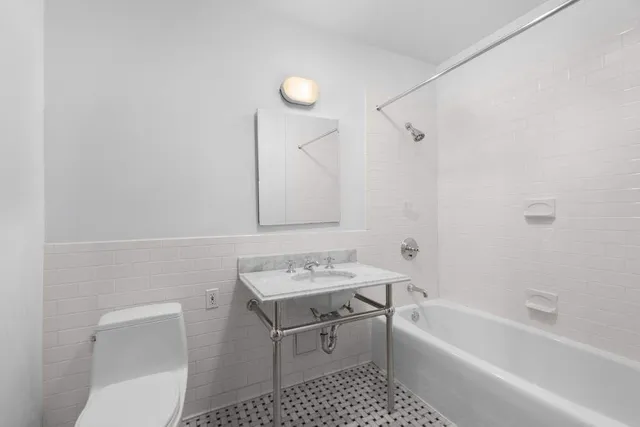 a bathroom with a sink mirror toilet and bathtub