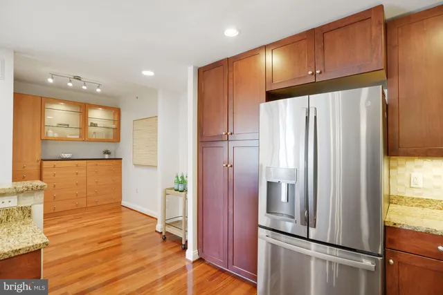 a view of a kitchen with kitchen island granite countertop wooden floors and a sink