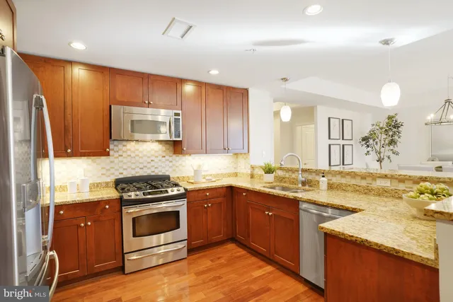 a kitchen with granite countertop a stove cabinets and wooden floor