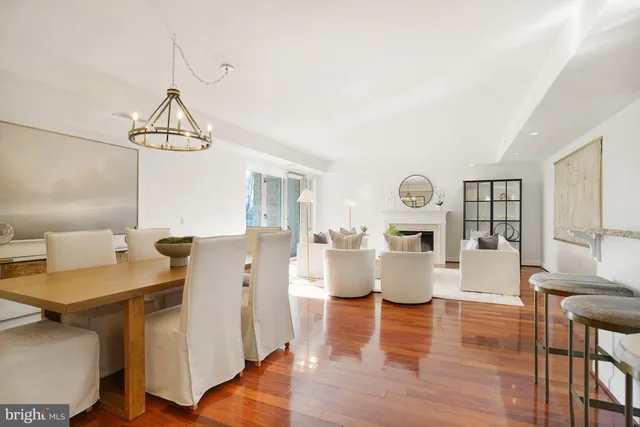 a living room with couches and kitchen view with wooden floor